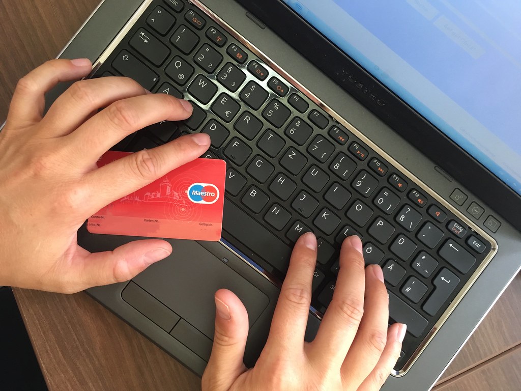 koszyk zakupowy i lupa nad kartą płatniczą